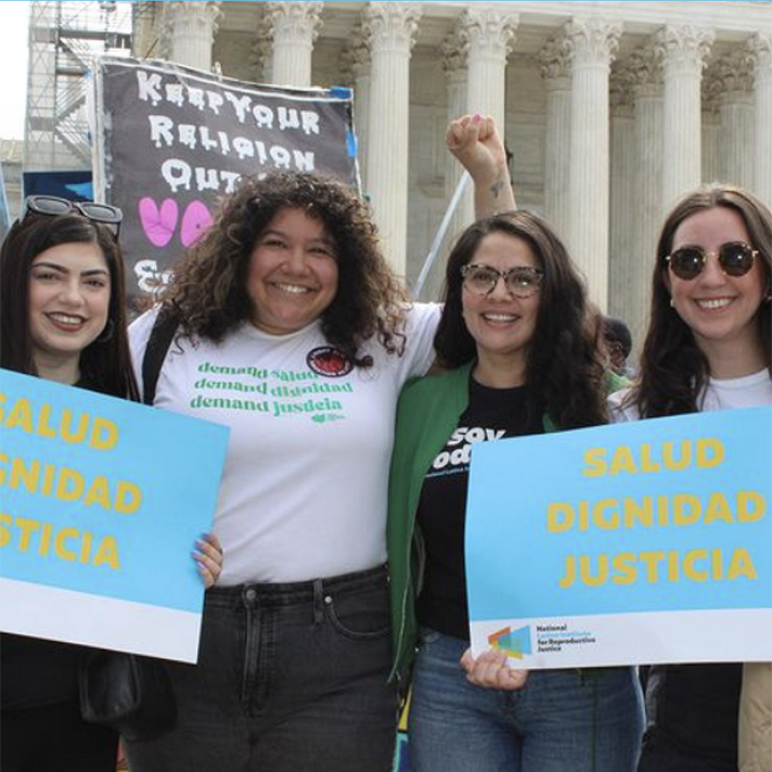 four women holding signs